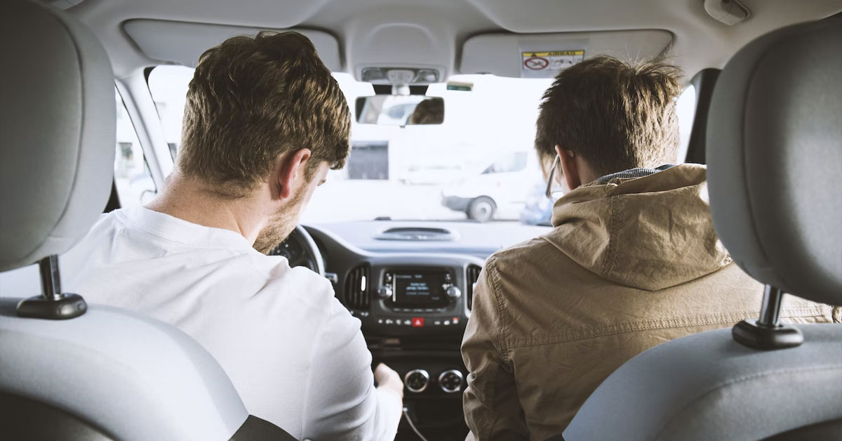 An image of two men sharing a car drive together