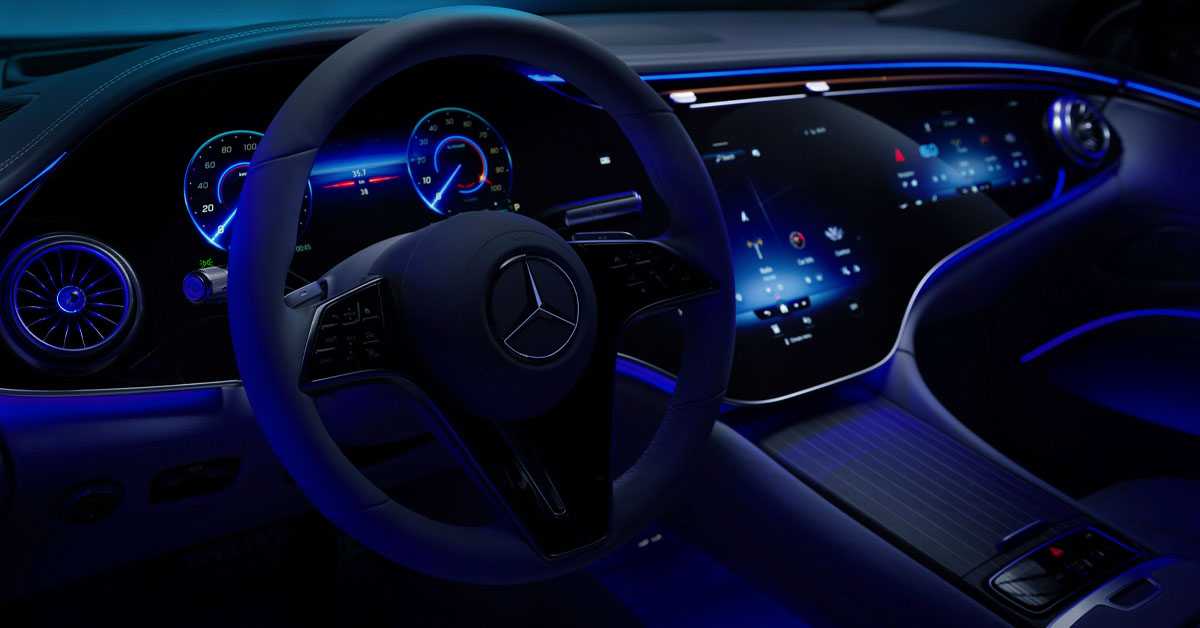 A picture of the Mercedes-Benz EQS steering wheel in the dark featuring ambient lighting