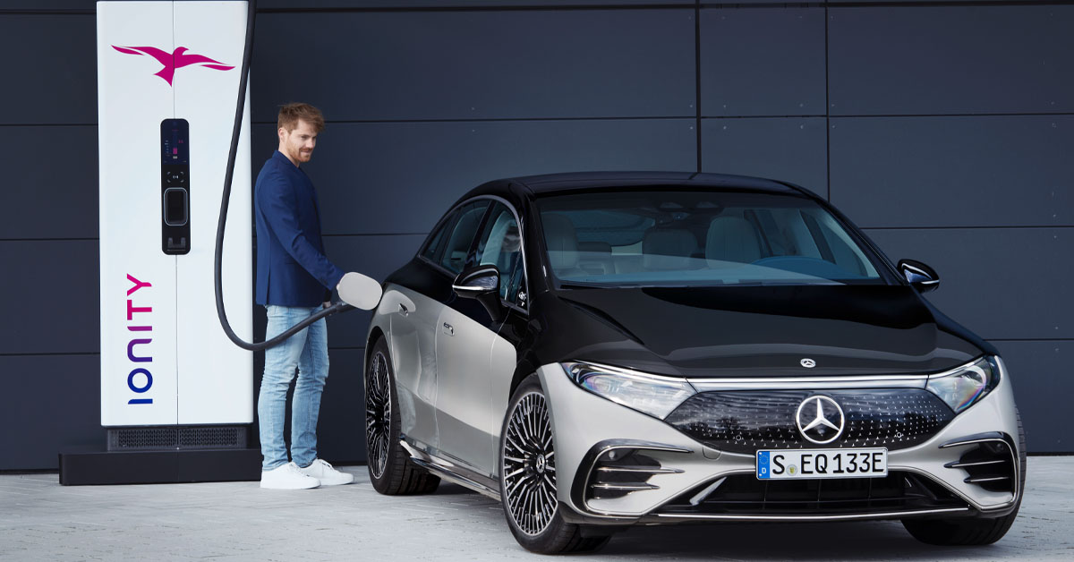 A picture of the Mercedes-Benz EQS being charged at an electric charging station