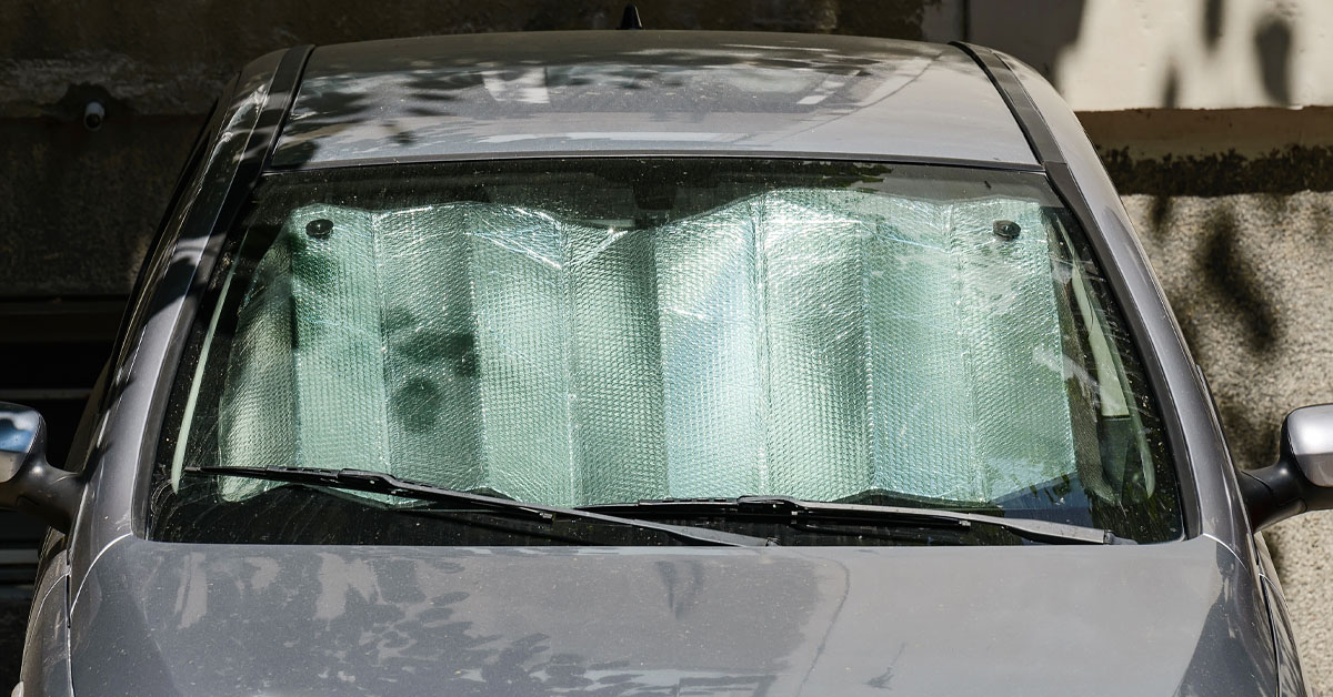 An image of a car with a reflective foil windscreen cover placed inside