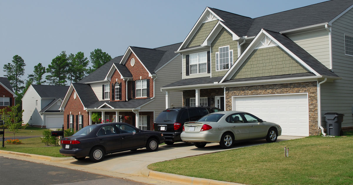 An image showing cars parked outside a house on a driveway