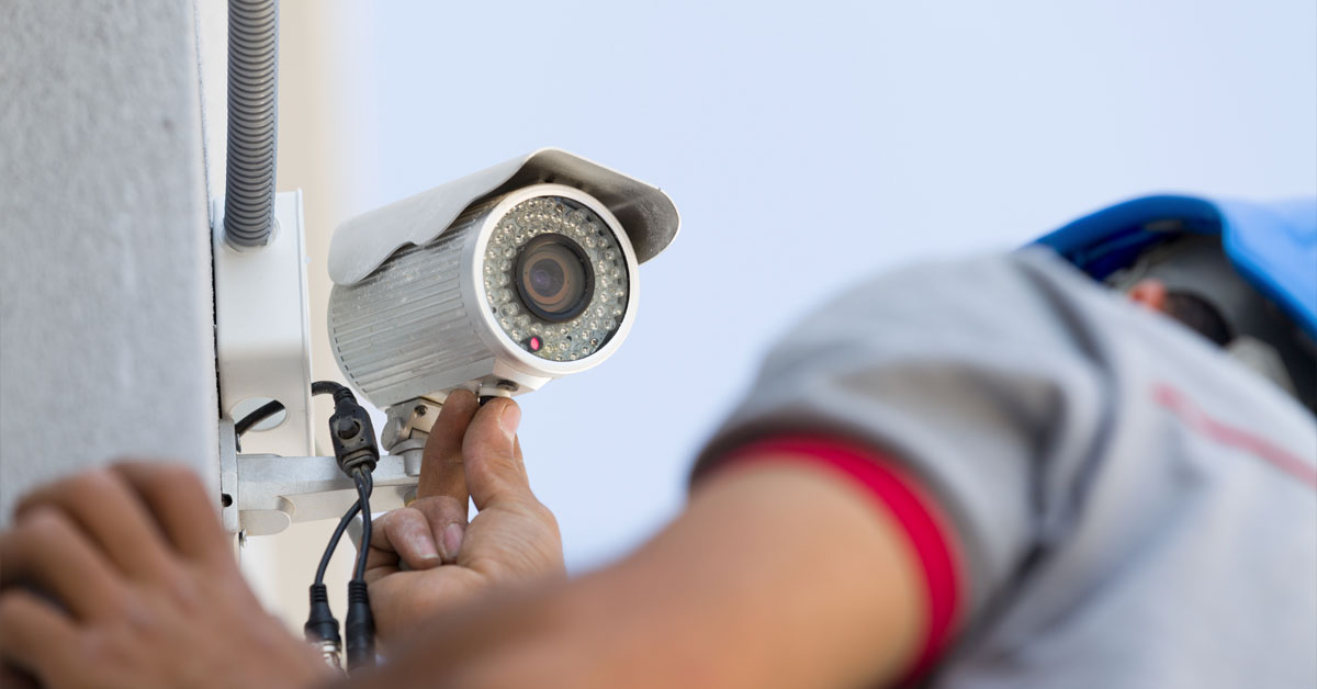 An image showing a CCTV camera being installed by a man